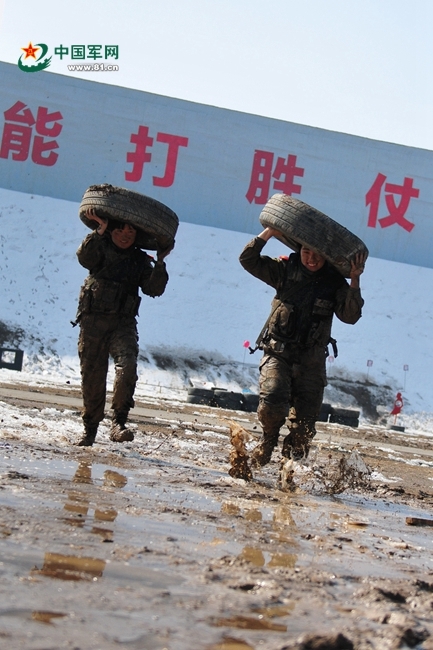 3月6日,女子特勤分队队员在泥潭中进行扛轮胎冲刺训练
