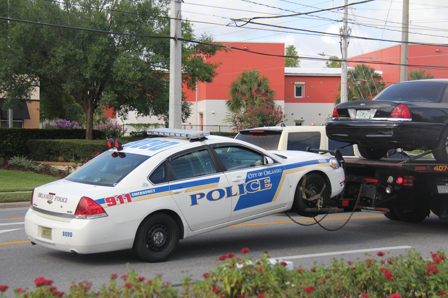 一辆被子弹打爆胎的警车被运离现场.本报记者 张朋辉摄.