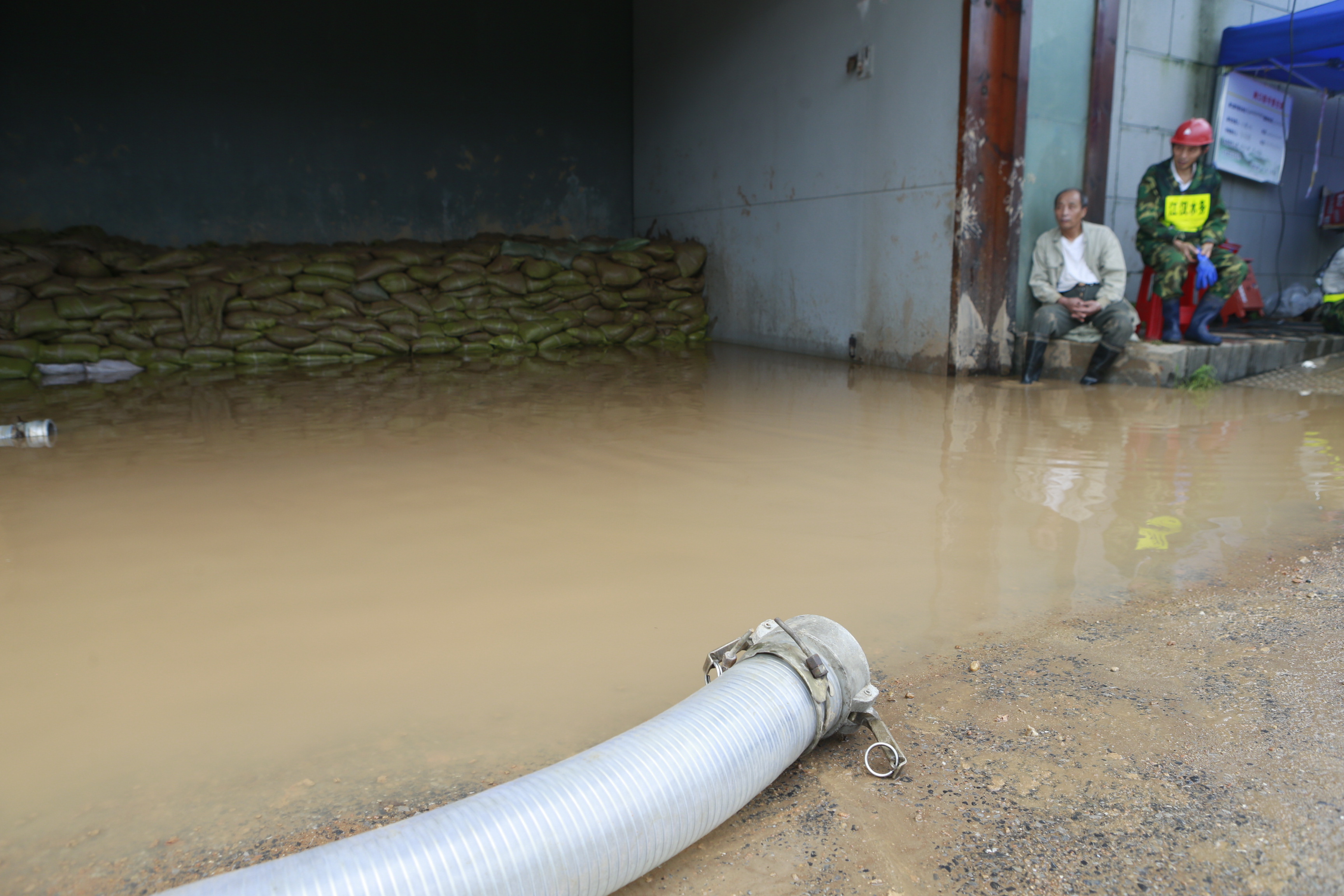9 武汉水务工作人员奋力抽除积水加固堤坝