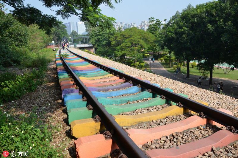 公园内,一段废弃的铁路路轨被涂上红,橙,黄,绿,青,蓝,紫七种颜色,宛如