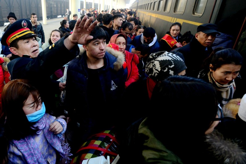 列车长牛军在乌鲁木齐火车南站站台上疏导旅客上车.