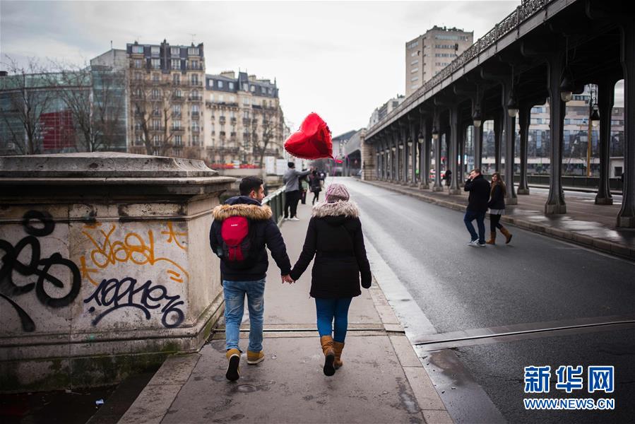 2月14日情人节,在法国巴黎埃菲尔铁塔前的比尔哈克姆桥,一对夫妇合影.