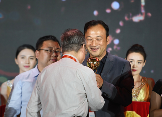 (图说:邬贺铨院士亲手将金奖奖杯交到阿里巴巴集团副总裁刘松手上)