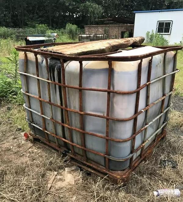 塑料吨桶装满不明液体且已破损,刺激性气味使人无法靠近.