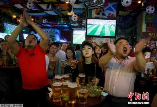 资料图：6月14日，北京的一家酒吧里，球迷们在观看世界杯揭幕战时激情庆祝。