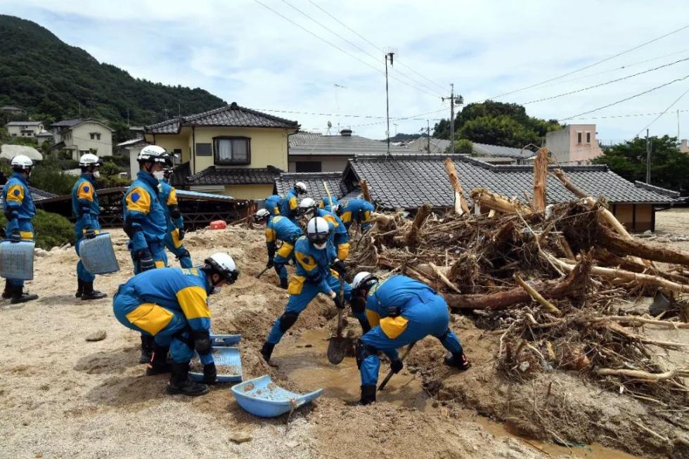 7月11日，在日本广岛吴市天应町地区，警察挖掘被泥石流淹没的民居。新华社记者马平摄