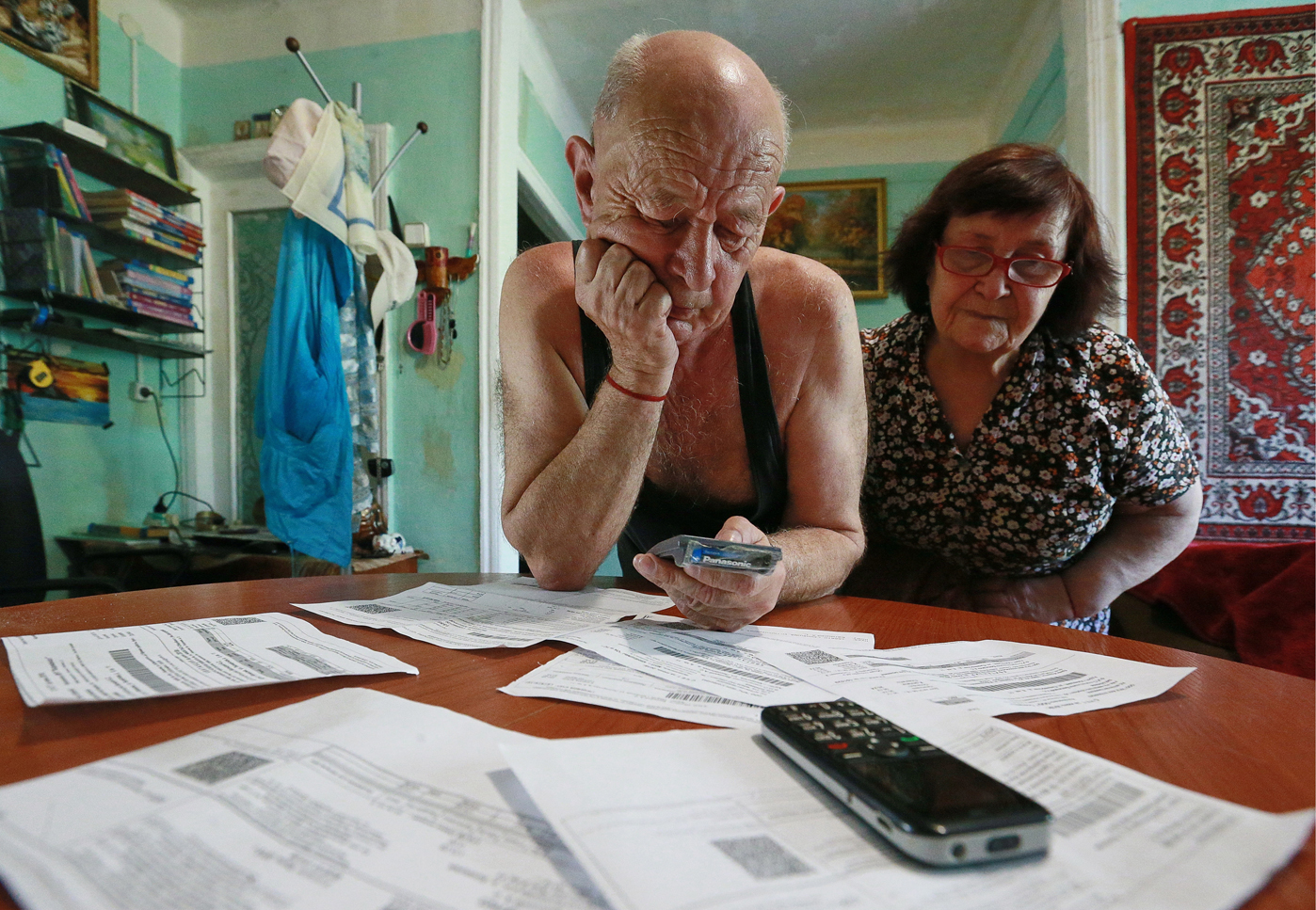两位俄罗斯老人在查看房费和物业费单据.