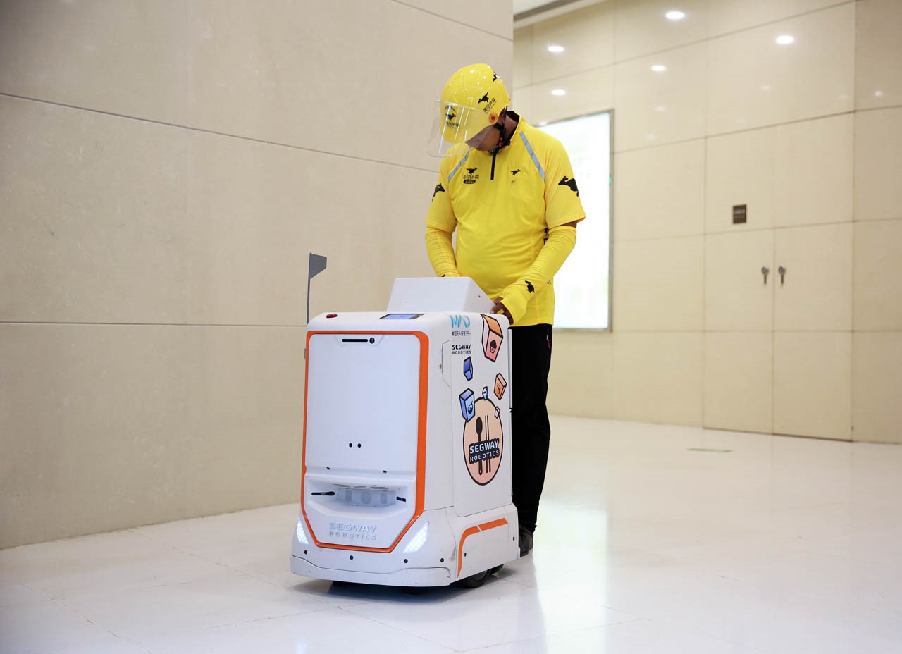 美团外卖小哥从segway配送机器人中取餐