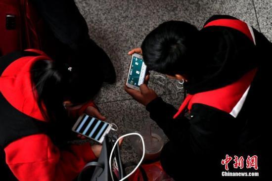 资料图：手机用户正在用手机打游戏。王东明 摄