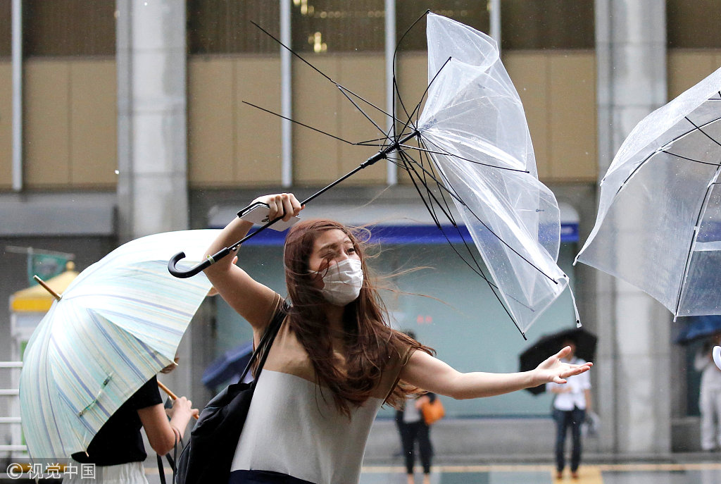 台风姗姗来袭日本民众伞被吹翻出行艰难