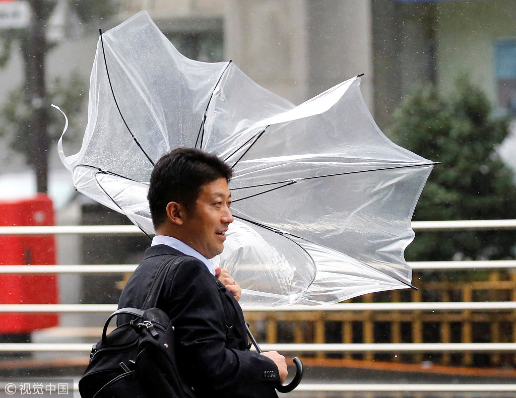 当地时间2018年8月8日,日本东京,台风"姗姗"逼近日本,民众用雨伞抵挡