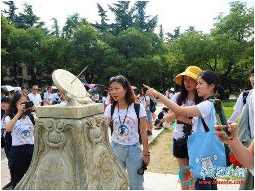 清华学生向两岸大学生介绍位于清华大学礼堂前大草坪南端的古典计时器――日晷