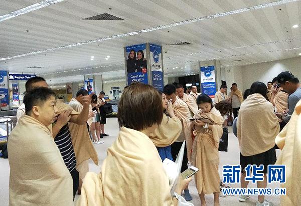 8月17日凌晨，乘坐厦航客机的乘客在飞机降落后在菲律宾马尼拉机场等候。 新华社发