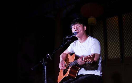 民谣歌手王亚伟在台儿庄古城边弹边唱