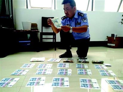 秭归县公安局民警王嵩整理查获的假币。