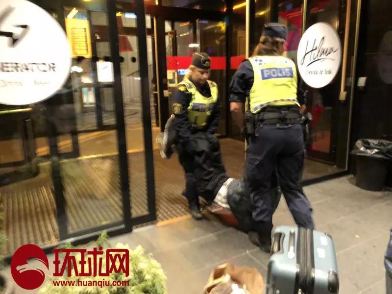 中国游客曾先生的父亲被瑞典警察抬出旅店。