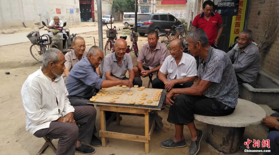 吴洪甫闲暇时常在村里与朋友下象棋 房现玉摄