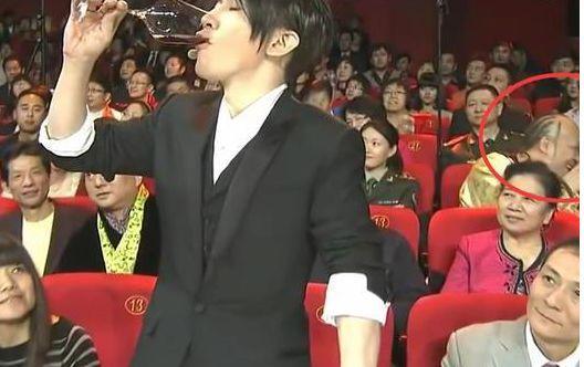 刘谦后身有位老大爷，看出了破绽，笑嘻嘻的跟身旁的女士解说起来。