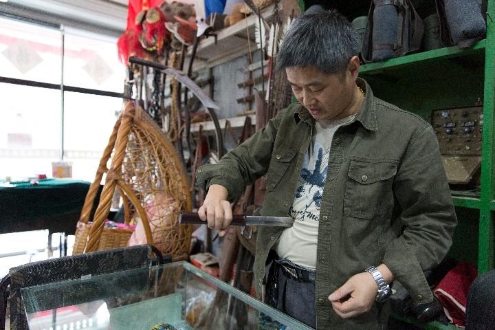 “道具大王”朱冬青正在展示自制的“伸缩匕首”道具。新华社记者殷晓圣摄
