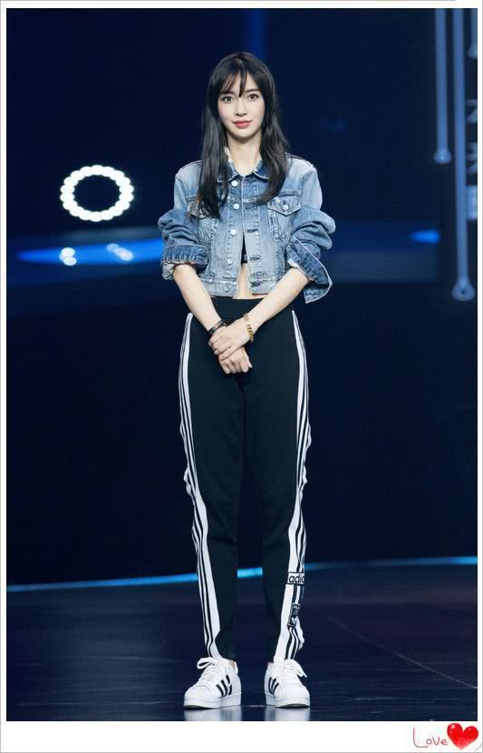 baby穿了一件短款的牛仔外套,下边是一件黑色运动长裤,搭配经典小白鞋