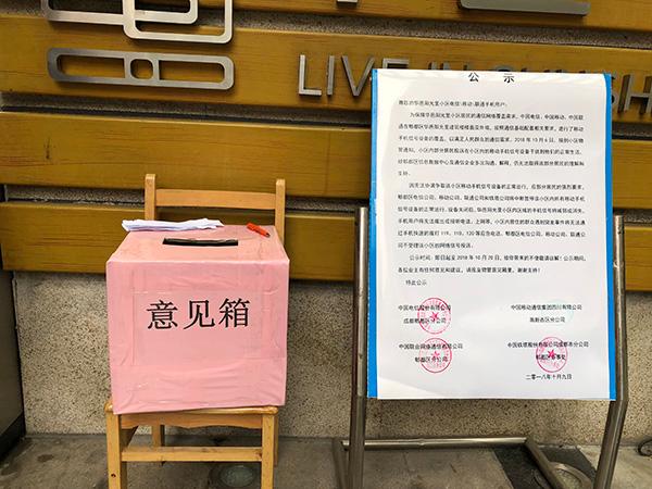 小区正门口摆放着运营商的告示，以及业主自主投票意见箱。澎湃新闻记者 陈凯姿图