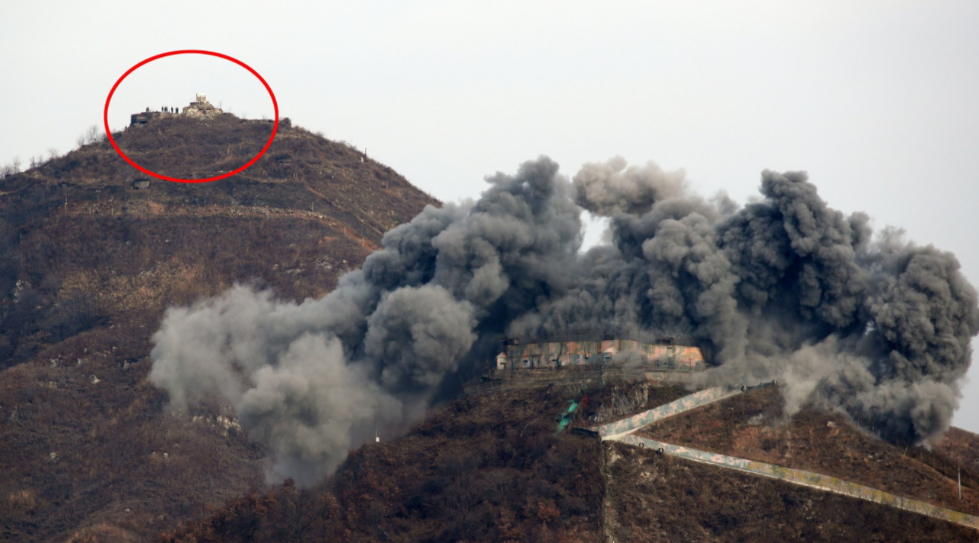 15日，韩军用TNT炸毁哨所，朝鲜军人远处观看。(韩国《中央日报》)