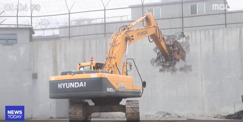 韩国用挖掘机拆除哨所画面。(韩国MBC新闻)