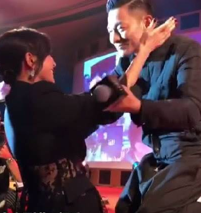 然后，刘嘉玲伸双手拍拍华仔的脸，将他的头拉近自己。