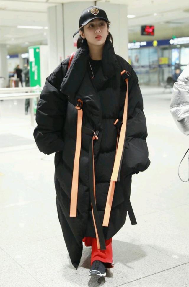 杨紫身穿橙色飘带羽绒服,飘带设计创意满分时髦度高,红色运动裤则更加跳脱。