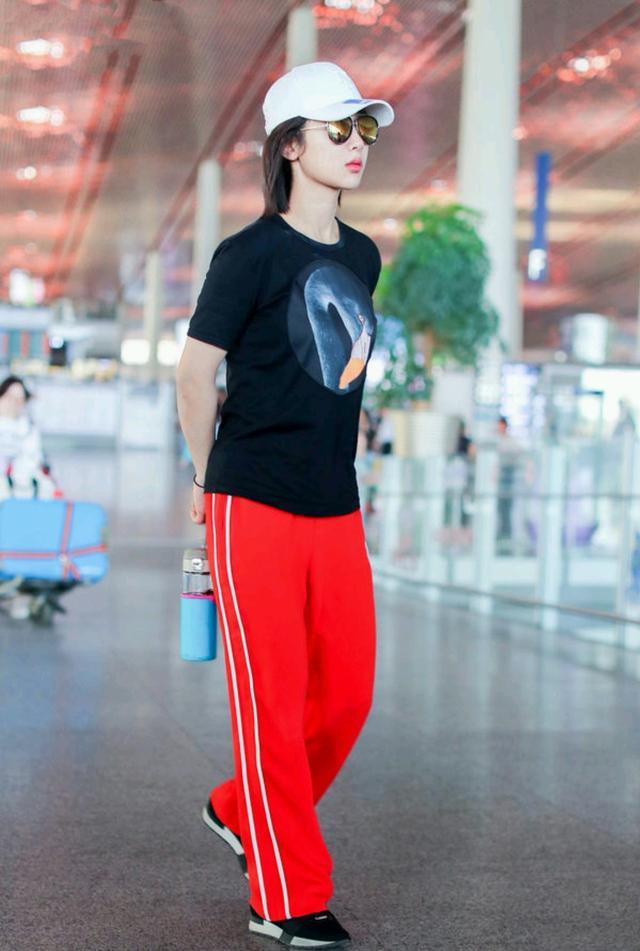 杨紫身穿黑色T恤搭配红色运动裤舒适又亮眼,棒球帽加墨镜搭配到位,这一身有点酷酷的感觉。