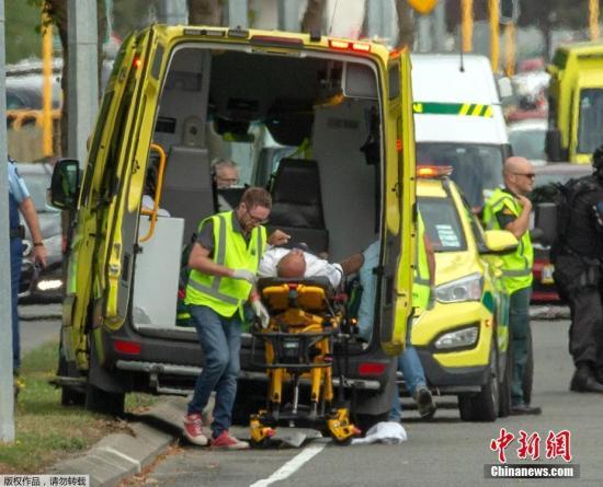 图为新西兰枪击案发生后，一名受伤人员被送入救护车。