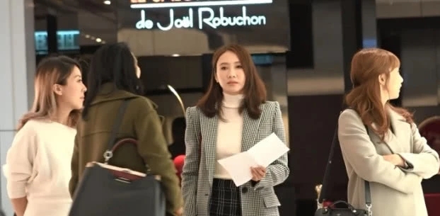 当天黎姿穿着女强人的装扮，手里还拿着纸。她和几位女士站在那不停聊天，看下去更像是聊公事。