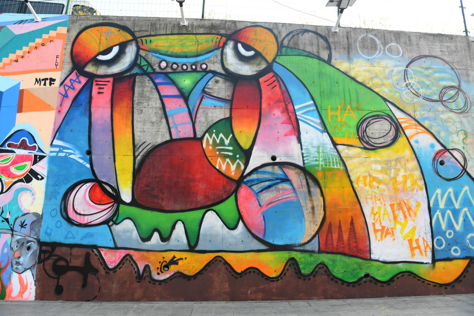 不过,近日在两江新区,多条马路边墙壁被成片的涂鸦装饰上了,色彩斑斓