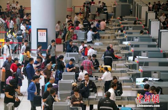 资料图：众多旅客在香港西九龙站接受安全检查。中新社记者 张炜 摄