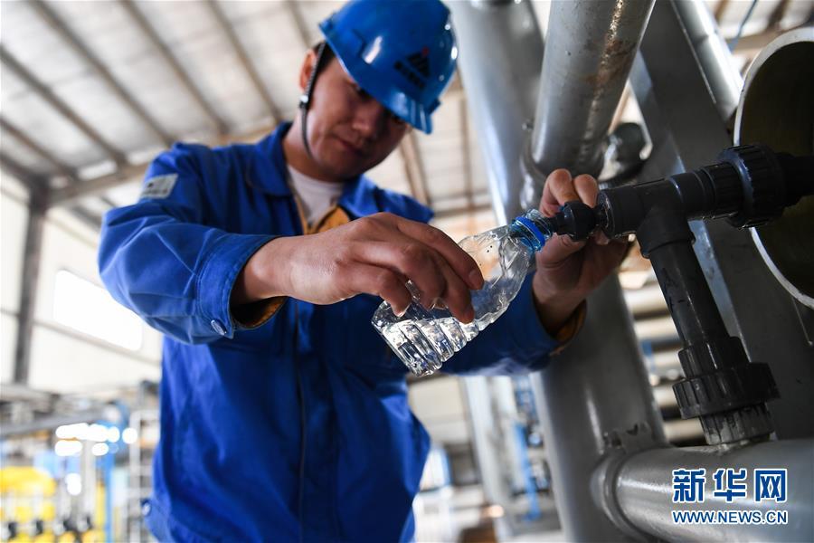 在国家能源集团鄂尔多斯煤制油分公司废水处理中心，一名工作人员展示经过处理后的污水（4月11日摄）。新华社记者 刘磊