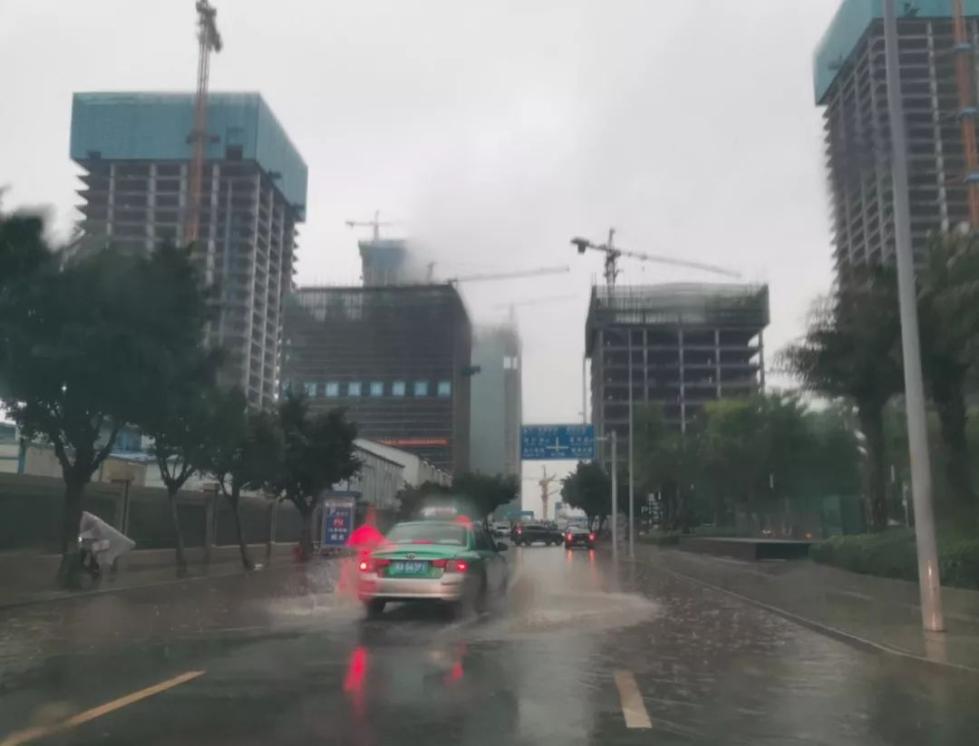 随着广州市区雨势加大，部分低洼路段出现积水，过往车辆小心通行。图为海珠区西二路