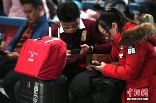 资料图：正在使用手机的年轻人。王东明 摄