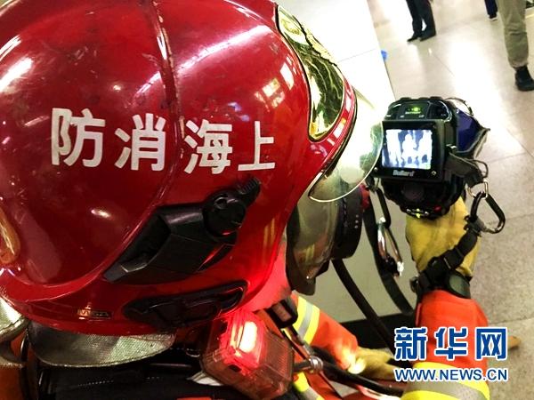 演习中的消防员正利用红外热像仪进行现场搜救。新华网 黄浩 摄