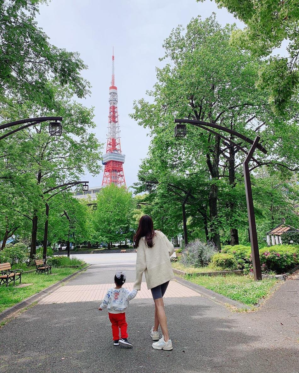 张子萱带女儿逛公园。