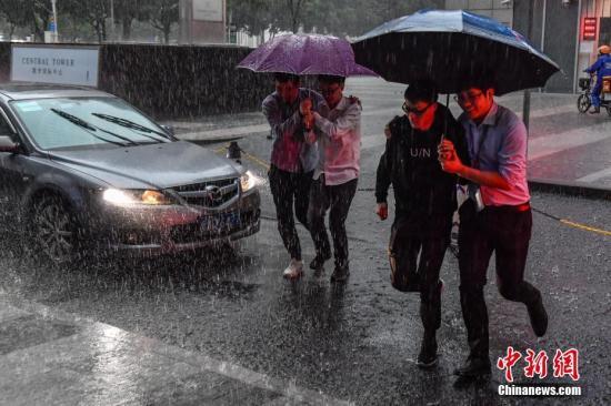 资料图：广州民众冒雨出行。中新社记者 陈骥旻 摄