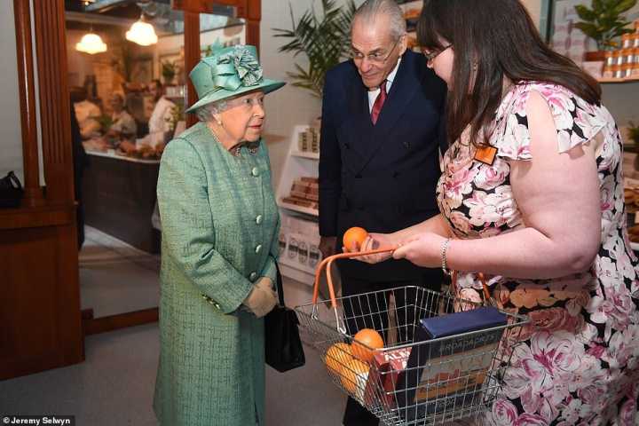 (工作人员向女王展示商品。图源：《每日邮报》)
