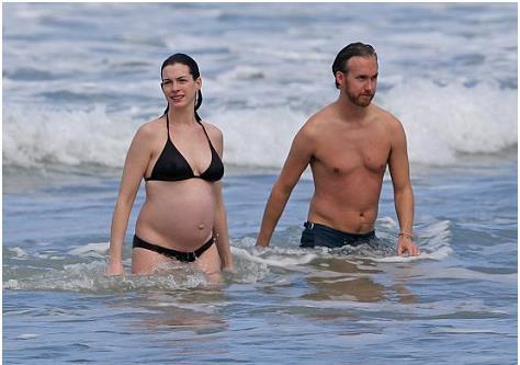 安妮·海瑟薇大肚穿比基尼在海中畅泳，幸福甜蜜溢于言表。