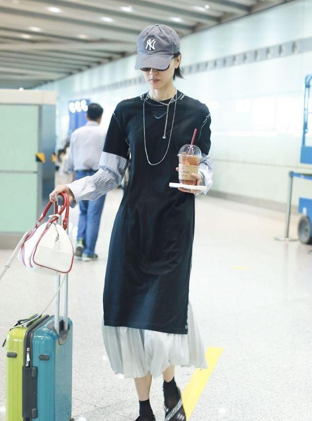 日前，杜鹃现身北京机场，穿袜子搭拖鞋，时尚混搭抢镜，自推行李超模气场十足。