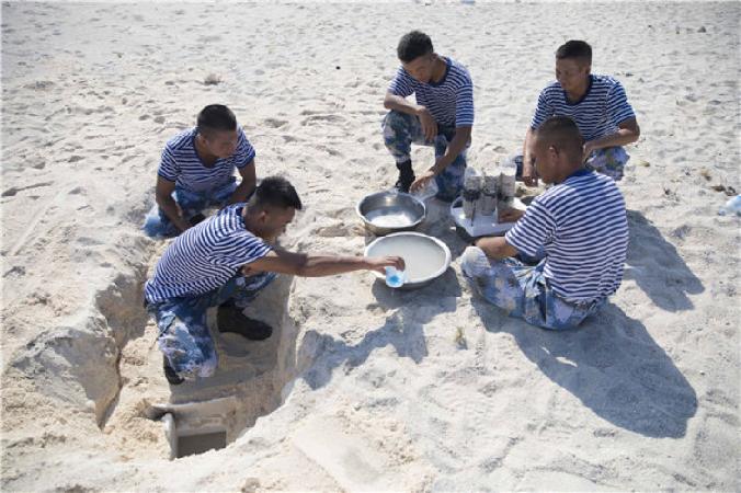 中建岛守备营官兵在野外生存训练中挖岛水过滤（5月22日摄）。新华社记者 琚振华 摄