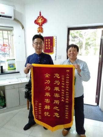 图说:失主王先生昨天到111路上海体育场起讫站赠送锦旗 车队供图