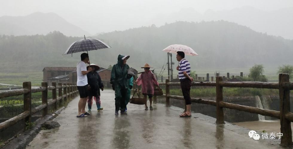 ▲泰宁大田乡基层干部冒雨疏散河道边的人员。