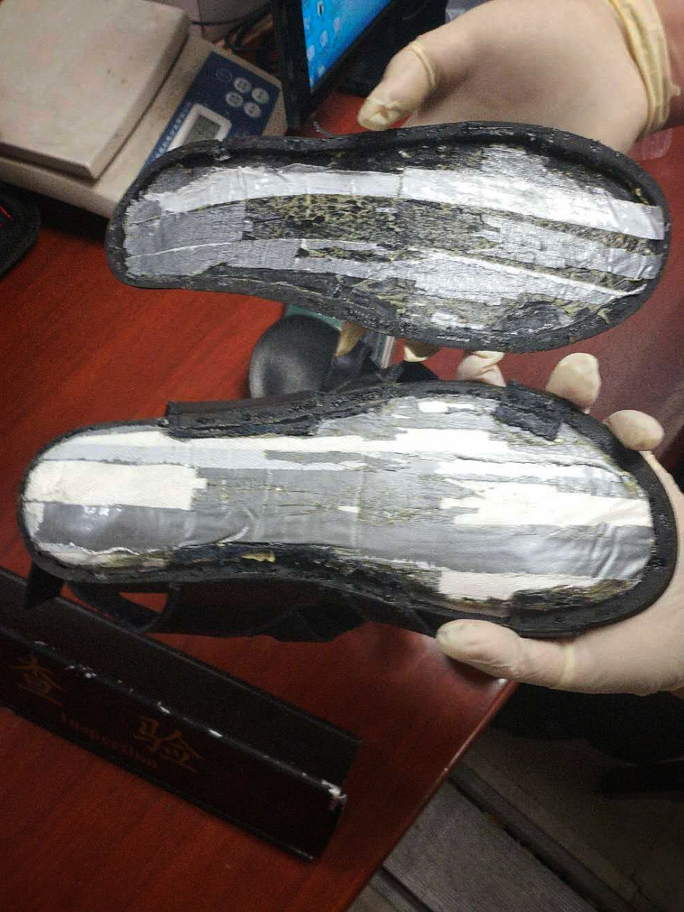 海关人员在拖鞋夹层中发现疑似毒品的粉末状物