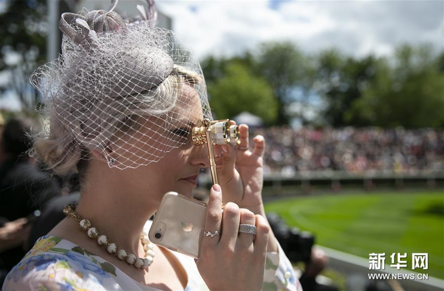6月22日，在英国阿斯科特，一名女士观看皇家阿斯科特赛马会。新华社记者 韩岩 摄