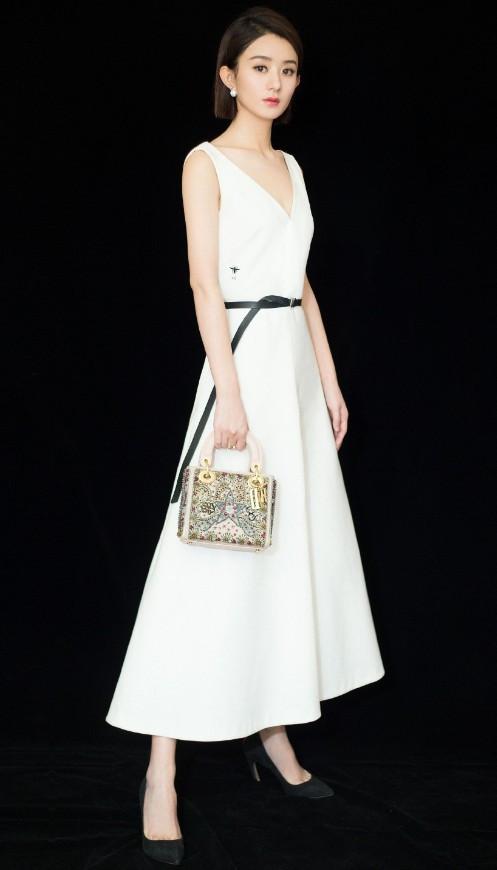 腰间的黑色腰带和脚上的高跟鞋相呼应,而赵丽颖手上拿着的包包珠光