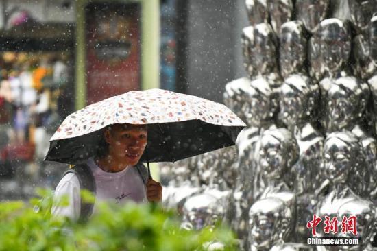 市民穿雨衣出行。中新社记者 张兴龙 摄